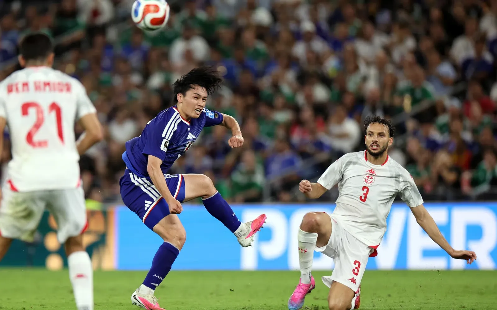 Mid-air battle as Japan's attacker rises high to win the aerial duel against Tunisia's defense.